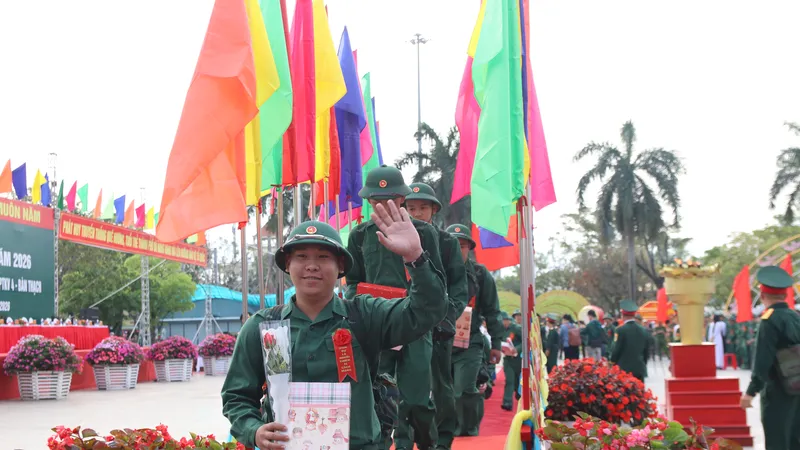 Công dân cười tươi vẫy tay chào người thân sau khi đi qua cầu vinh quang. Ảnh: NGUYỄN CƯỜNG