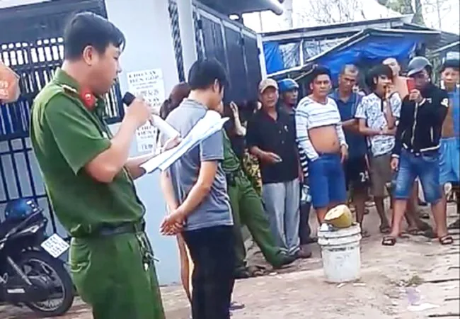 Người mặc sắc phục công an cầm micro đọc to hành vi mua bán dâm.Hành động này đã gây bức xúc trong dư luận. (Ảnh cắt từ clip)