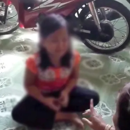 Bé gái 10 tuổi đang kể vụ việc với một người phụ nữ. Ảnh cắt từ clip