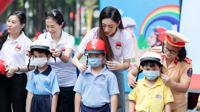 Hoa hậu Lương Thùy Linh vận động đội mũ bảo hiểm cho trẻ em