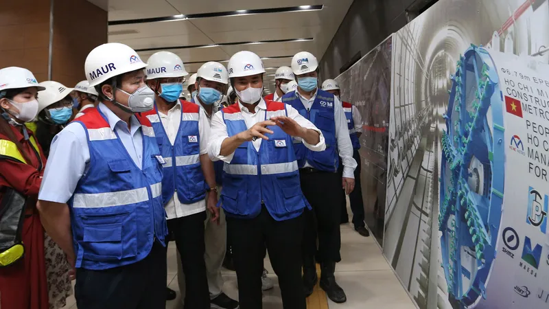  Chủ tịch UBND TPHCM Nguyễn Thành Phong tham quan công trường Ga Nhà hát Thành phố của tuyến đường sắt đô thị số 1 tuyến Bến Thành - Suối Tiên với sự hướng dẫn của Trưởng Ban quản lý Đường sắt đô thị Bùi Xuân Cường. Ảnh: HOÀNG HÙ