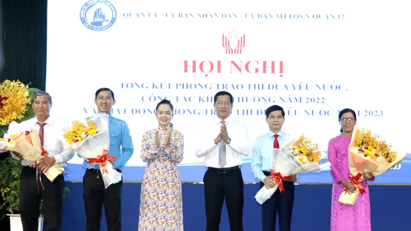 Bí thư Quận ủy quận 12 Trần Hoàng Danh và Phó Giám đốc Sở Nội vụ TPHCM Ngô Thị Hoàng Các tặng hoa chúc mừng các tập thể được nhận cờ thi đua của TPHCM