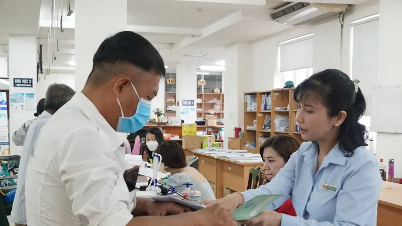 Viên chức bộ phận một cửa BHXH TPHCM hướng dẫn người dân làm hồ sơ