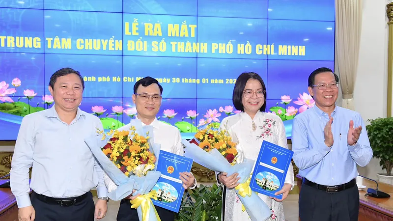Chủ tịch UBND TPHCM Phan Văn Mãi và Phó Chủ tịch UBND TPHCM Dương Anh Đức trao quyết định, hoa chúc mừng bà Võ Thị Trung Trinh và ông Nguyễn Đức Chung. Ảnh: VIỆT DŨNG