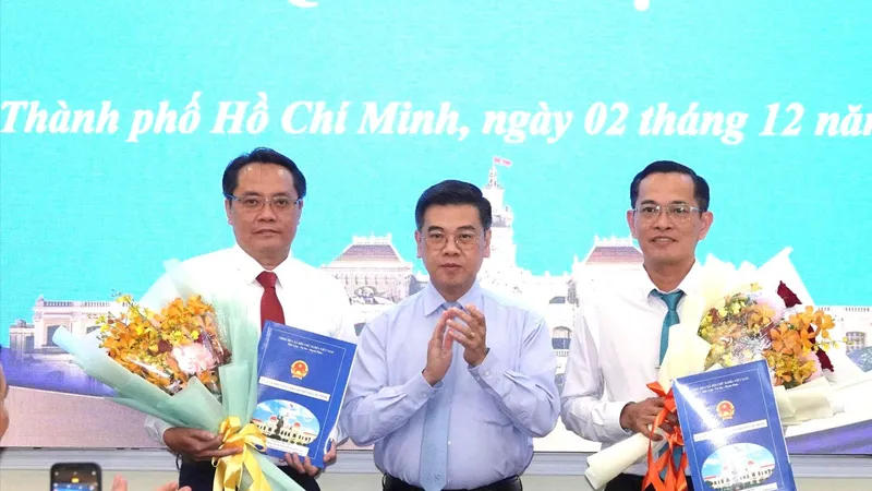 Phó Chủ tịch UBND TPHCM Nguyễn Văn Dũng trao quyết định và hoa chúc mừng ông Trương Công Huy và ông Phan Tấn Thảo