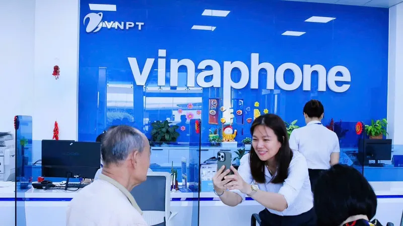 Nhân viên VinaPhone giúp khách hàng xác nhận sinh trắc học đăng ký thuê bao di động.