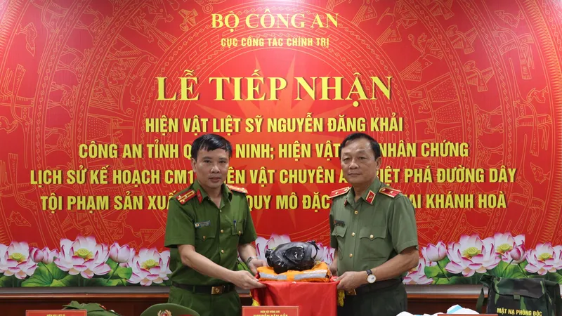 Đại diện Cục Cảnh sát điều tra tội phạm về ma túy trao tặng hiện vật sử dụng trong chuyên án triệt phá tổ chức tội phạm sản xuất trái phép ma túy tại Khánh Hòa. Ảnh: HOA NGUYỄN