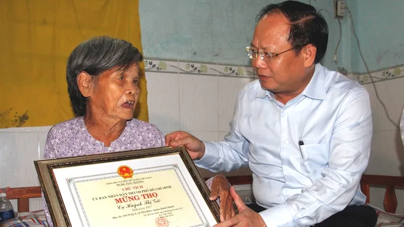 Phó Bí thư Thường trực Thành ủy TPHCM Tất Thành Cang mừng thọ cụ Huỳnh Thị Giờ. Ảnh: TUẤN VŨ