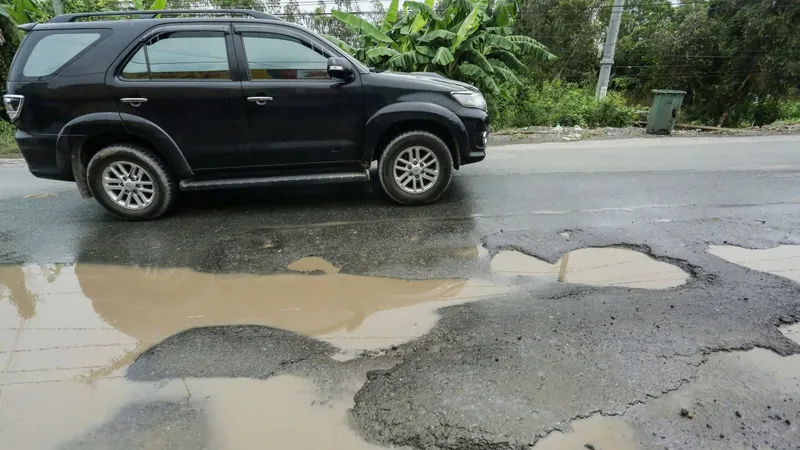 Mặt đường Quốc lộ 62 chi chít ổ gà, ổ voi, ngập nước khi trời mưa