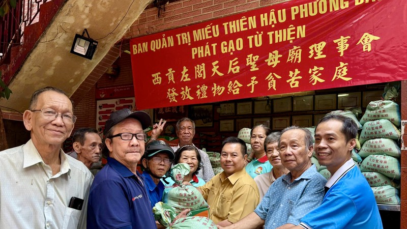 棋盘坊代表和天后圣母庙理事派发礼品予家境清寒人家。仁建/摄