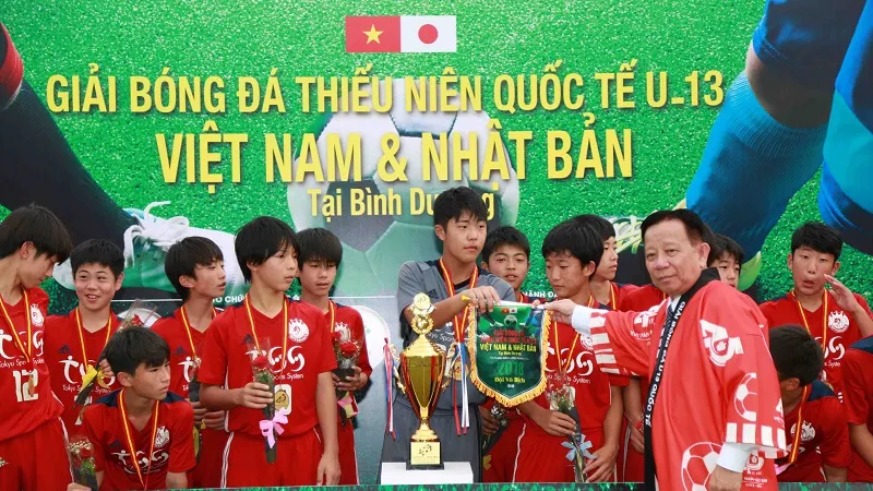 Ban tổ chức trao cờ vô địch cho đội Nhật Bản. Ảnh: DŨNG PHƯƠNG