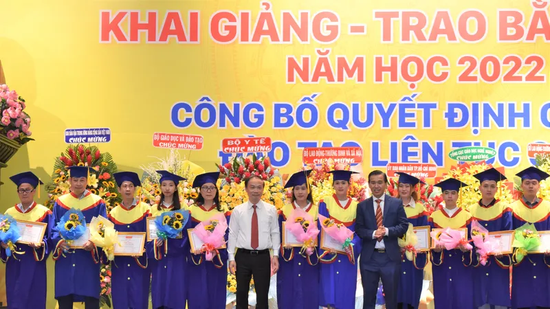Ông Phạm Tất Thắng, Phó trưởng ban Thường trực Ban Dân vận Trung ương (áo trắng) và TS Lê Lâm, Hiệu trưởng Trường Cao đẳng Đại Việt Sài Gòn trao giấy khen và hoa cho đại diện 177 sinh viên học tập xuất sắc, học giỏi tốt nghiệp ra trường