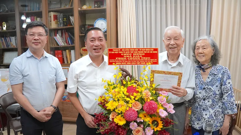 Đồng chí Phạm Thành Kiên, Trưởng Ban Tổ chức Thành uỷ (thứ 2 từ trái vào) thăm, chúc mừng nhà giáo Phạm Chánh Trực. ẢNH QUANG HUY