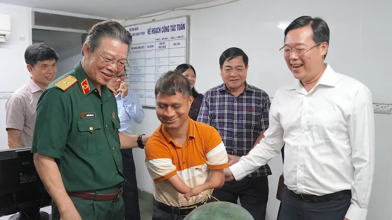 Đồng chí Lê Quốc Phong (ngoài cùng bên phải) cùng PGS-TS-BS Nguyễn Hồng Sơn thăm hỏi bạn trẻ tại Hội nạn nhân chất độc da cam/dioxin TPHCM. Ảnh: QUANG HUY