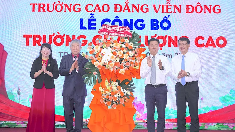 GS.TS Lê Quân, Thứ trưởng Bộ GD-ĐT (thứ 2 từ phải vào) tặng hoa chúc mừng nhà trường. ẢNH QUANG HUY