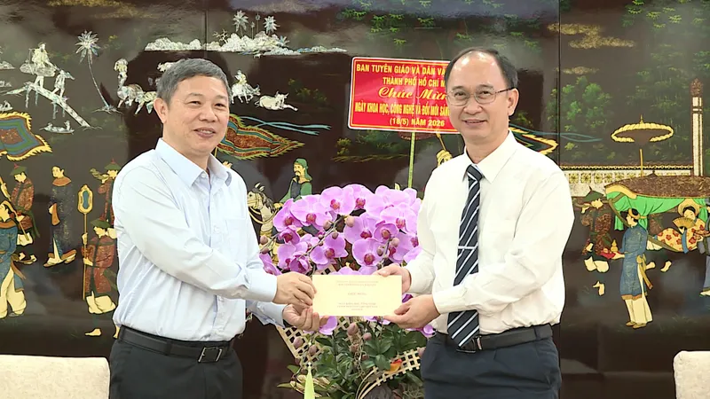 Đồng chí Dương Anh Đức chúc mừng PGS.TS Trần Cao Vinh. ẢNH QUANG HUY