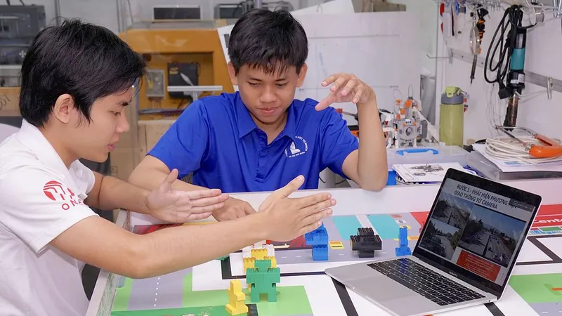 Anh Trần Mai Khiêm - cử nhân tài năng CNTT khóa 2016 và Hoàng Trung Hiếu (bên phải) - cử nhân tài năng CNTT khóa 2015 đang nghiên cứu hoàn thành dự án “Điều khiển đèn giao thông thông minh” qua camera. Ảnh: HOÀNG HÙNG
