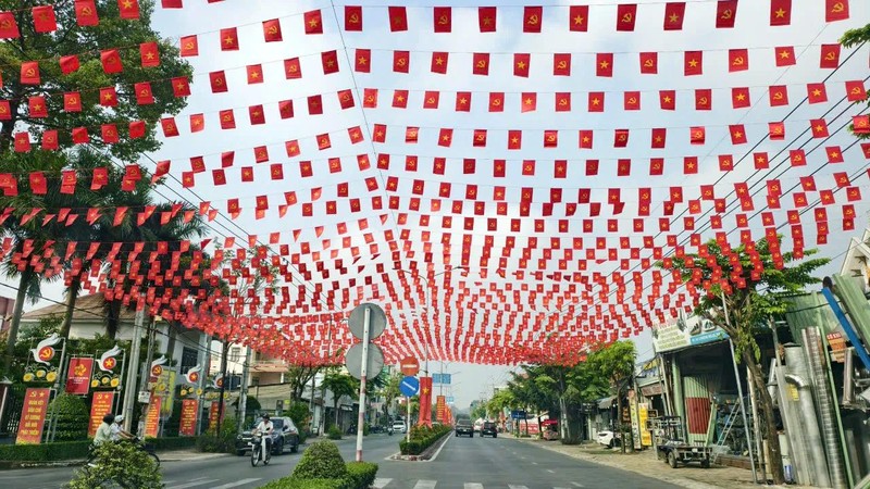 Phu Loi Street in Phu Loi Ward is brightly adorned with flags and flowers. (Photo: SGGP)