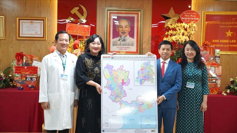 Ms. Bui Thi Hong Suong, Deputy Editor-in-Chief of Sai Gon Giai Phong Newspaper (2nd, L), presents the Map of Ho Chi Minh City’s Administrative Units to People's Hospital 115. (Photo: SGGP)
