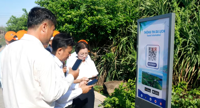 Tourists scan the QR Code to access travel information at the sovereignty flagpole of Phu Quy Special Zone in Lam Dong province. (Photo: VNA)