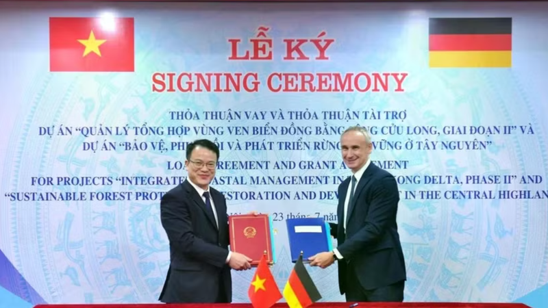 Deputy Minister of Finance Tran Quoc Phuong (left) and a representative of the German Reconstruction Bank (KfW) sign a loan agreement and a grant agreement for the two projects at a ceremony in Hanoi on July 23. (Photo: Ministry of Finance)