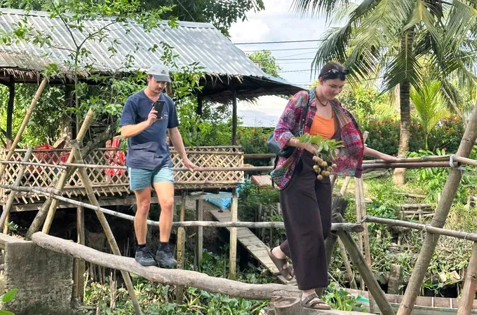 Tourists experience crossing a traditional monkey bridge.