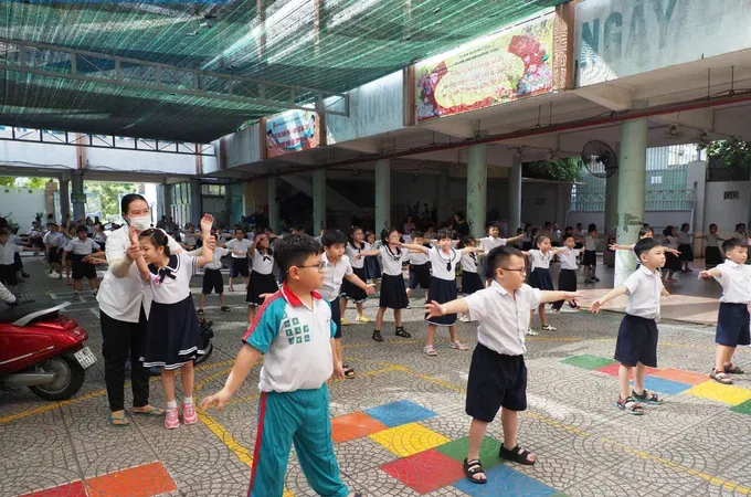 Students at Chuong Duong Primary School in Cau Ong Lanh Ward, HCMC exercise during recess. (Photo: SGGP)