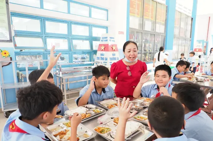 A health worker at Le Thi Rieng Primary School in Hoa Hung Ward, Ho Chi Minh City, listens to students’ feedback during a boarding meal on September 15. (Photo: SGGP)