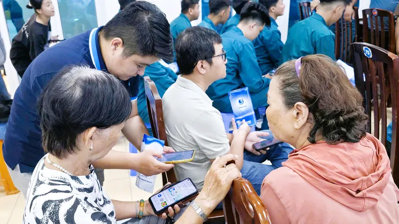 Nhân viên Công ty Cấp nước hướng dẫn và hỗ trợ người dân cài đặt ứng dụng SAWACO CSKH