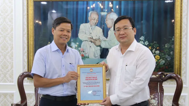 Phó Chủ tịch Ủy ban MTTQ Việt Nam TPHCM Phan Hồng Ân (phải) trao thư cảm ơn EVNHCMC