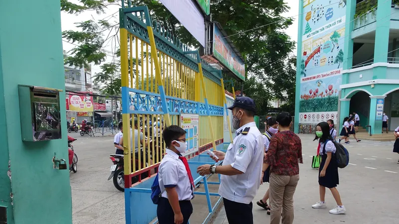 Học sinh Trường Tiểu học An Hội (quận Gò Vấp) được đo thân nhiệt ngay tại cổng trường