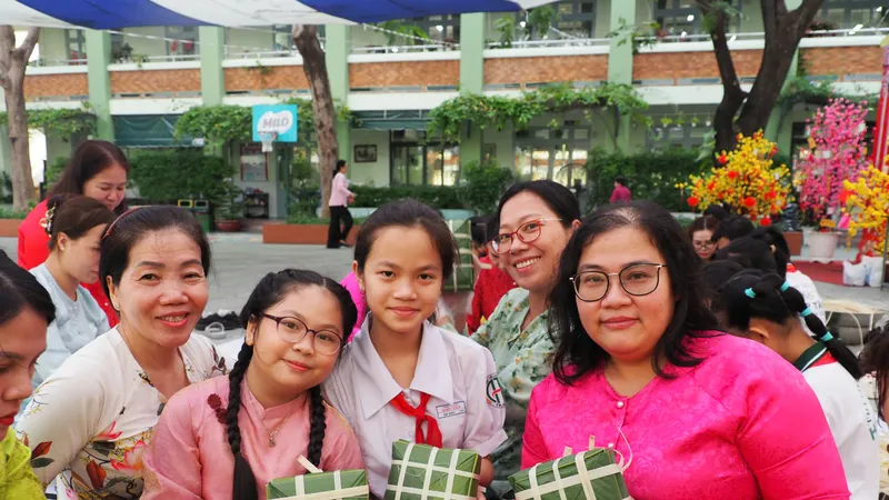 Học sinh, phụ huynh và giáo viên phấn khởi với những chiếc bánh chưng vừa gói tại hoạt động trải nghiệm "Gói bánh chưng ngày tết"