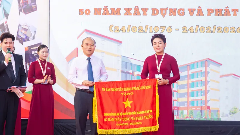 Phó Chủ tịch UBND TPHCM Trần Văn Bảy trao cờ truyền thống của UBND cho đại diện Trường Phổ thông đặc biệt Nguyễn Đình Chiểu.