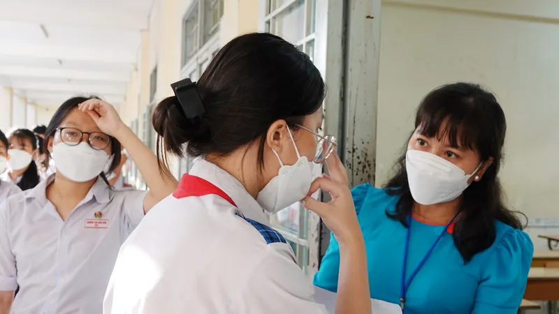 Giám thị kiểm tra giấy báo dự thi trước khi vào phòng thi. Ảnh: PHAN HUY