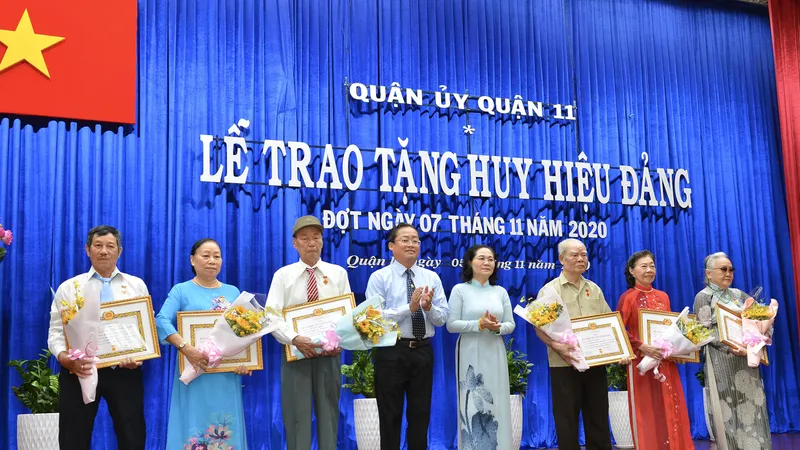 Đồng chí Nguyễn Thị Lệ, Phó Bí thư Thành ủy, Chủ tịch HĐND TPHCM trao huy hiệu Đảng cho các đảng viên tại quận 11. Ảnh: VIỆT DŨNG