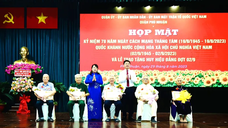 Chủ tịch Ủy ban MTTQ Việt Nam TPHCM Trần Kim Yến chúc mừng các đảng viên cao tuổi Đảng tại quận Phú Nhuận nhận Huy Đảng đợt 2-9. Ảnh: BÙI HẢI