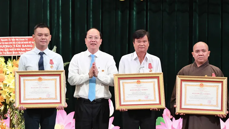 Phó Bí thư Thường trực Thành ủy TPHCM Nguyễn Hồ Hải trao Huân chương Lao động Ba của Chủ tịch nước đến 3 cá nhân. Ảnh: VIỆT DŨNG