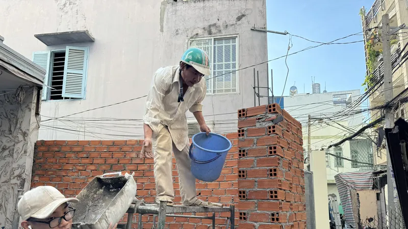 Người dân hẻm 76/47 Phan Tây Hồ, phường 7, quận Phú Nhuận thực hiện sửa lại nhà sau hiến đất. Ảnh: VIỆT DŨNG