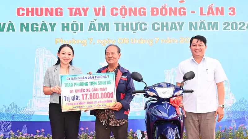 Niềm vui của người dân phường 7, quận Phú Nhuận khi được trao tặng phương tiện sinh kế là chiếc xe máy. Ảnh: VIỆT DŨNG
