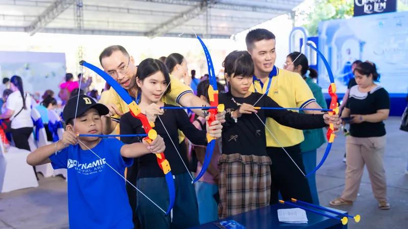 Trẻ em hoàn cảnh đặc biệt tham gia trò chơi bắn cung tại ngày hội "Giấc mơ Lọ Lem"