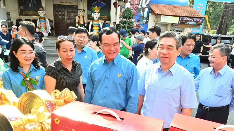 Đồng chí Nguyễn Đình Khang và đồng chí Nguyễn Phước Lộc tham quan gian hàng "Chợ Tết Công đoàn" tại TPHCM. Ảnh: VIỆT DŨNG