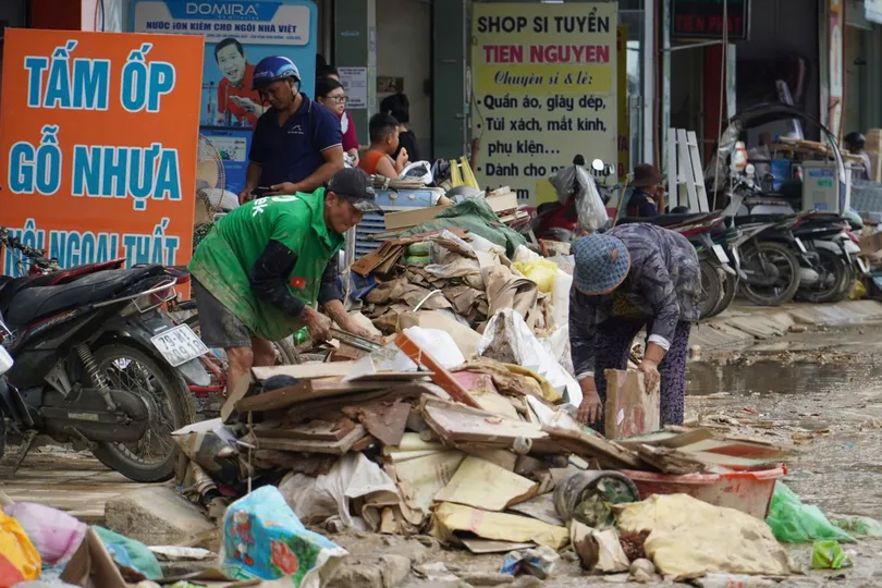 Người dân phường Tây Nha Trang (tỉnh Khánh Hòa) dọn dẹp rác tồn đọng sau trận lũ lịch sử. Ảnh: HIẾU GIANG
