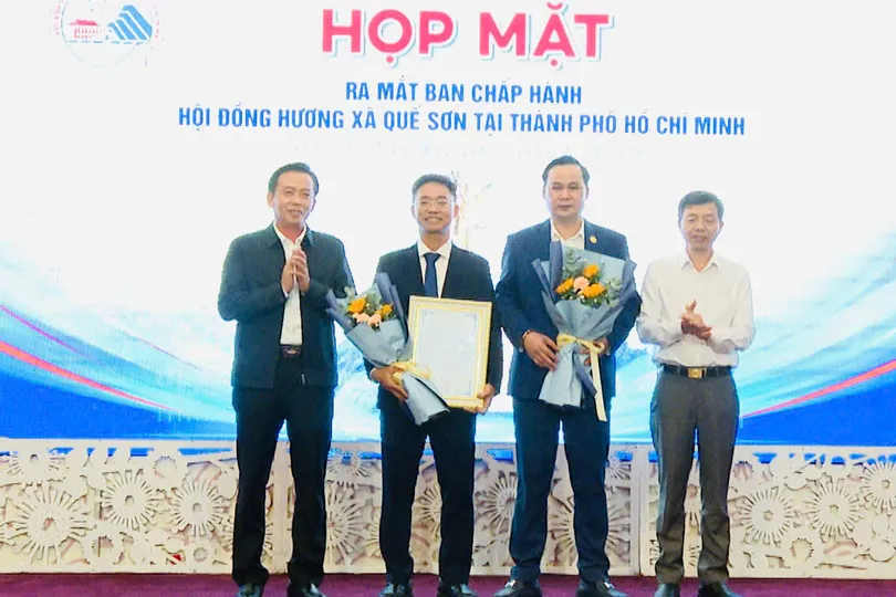 Ông Ngô Công Quang và ông Hà Văn Tự (giữa) nhận hoa chúc mừng từ lãnh đạo địa phương,