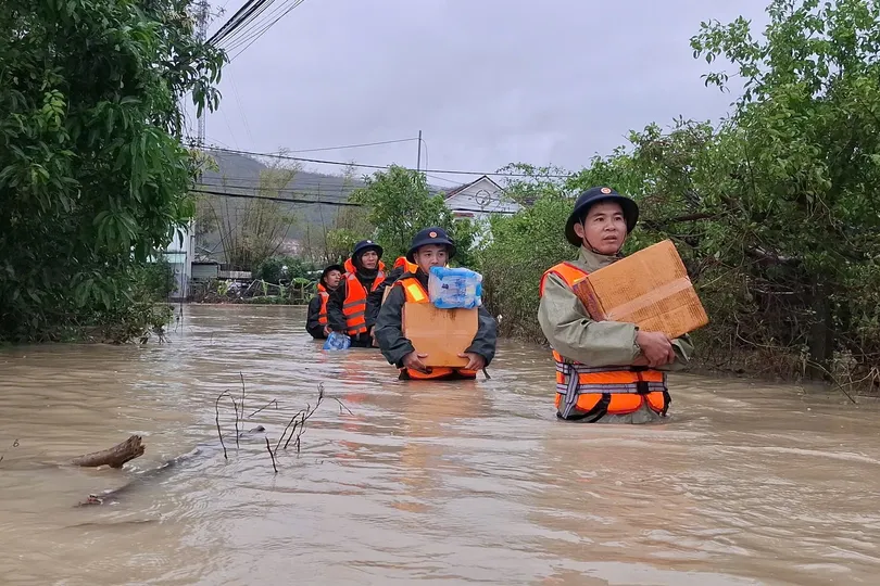 Các chiến sĩ lội nước vận chuyển nhu yếu phẩm hỗ trợ người dân