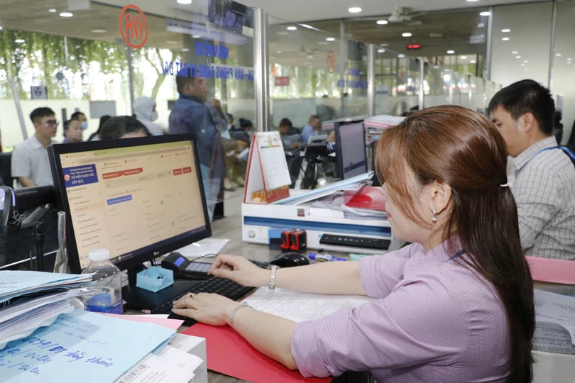 Cán bộ, công chức, viên chức quận 12 (TPHCM) tiếp nhận, xử lý hồ sơ cho người dân và doanh nghiệp. Ảnh: NGÔ BÌNH