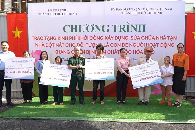 Các gia đình ở TPHCM đón nhận bảng tượng trưng kinh phí hỗ trợ xây dựng, sửa chữa nhà. Ảnh: MẠNH THẮNG
