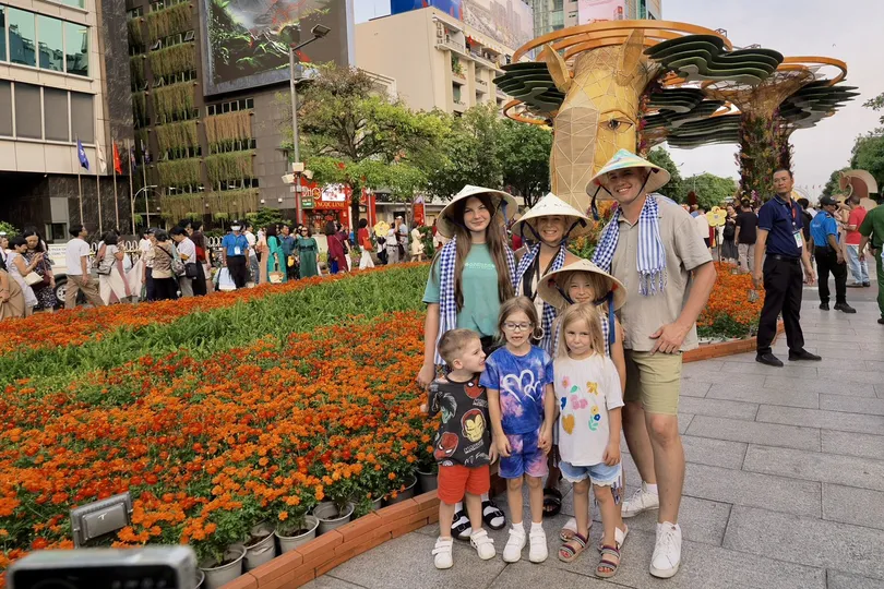 Du khách quốc tế tham quan đường hoa Nguyễn Huệ chiều 21-2