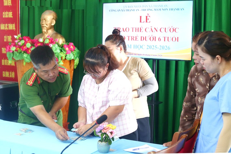 盛安乡公安长赵洪德中校向儿童监护人签发身份证。