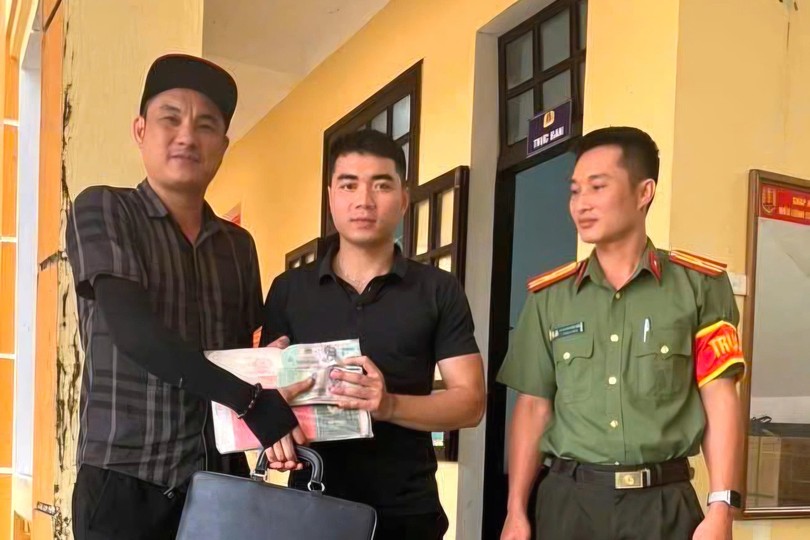  黄辉原（中）将遗失财物归还失主。