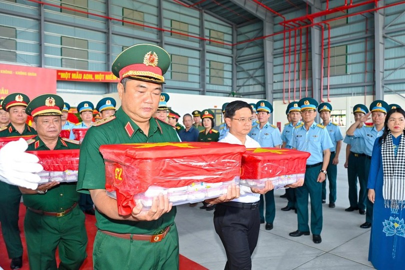 第七军区司令黎春世中将、市人委会副主席阮孟强与各位代表举行烈士遗骸样本登机仪式。孟胜摄